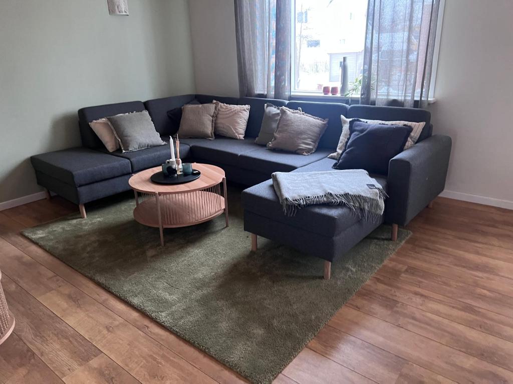 a living room with a blue couch and a table at Akureyri apartments in Akureyri