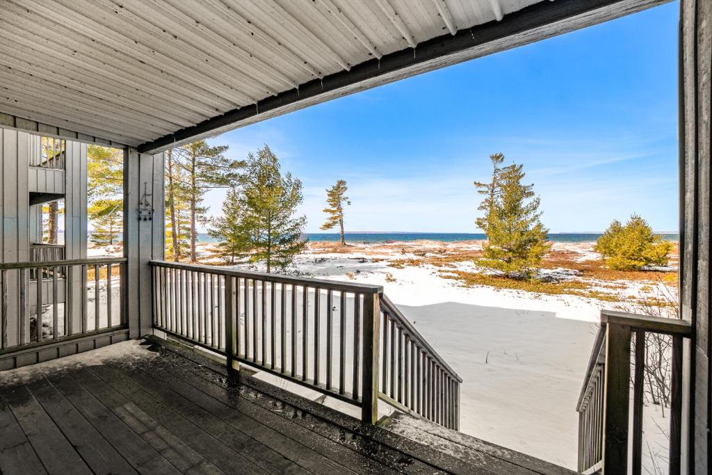 a screened porch with a view of the beach at South Beach 26 in Glen Arbor