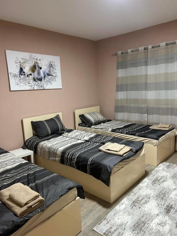 een slaapkamer met 3 bedden en een raam bij Apartments & Restaurant Despina in Prilep