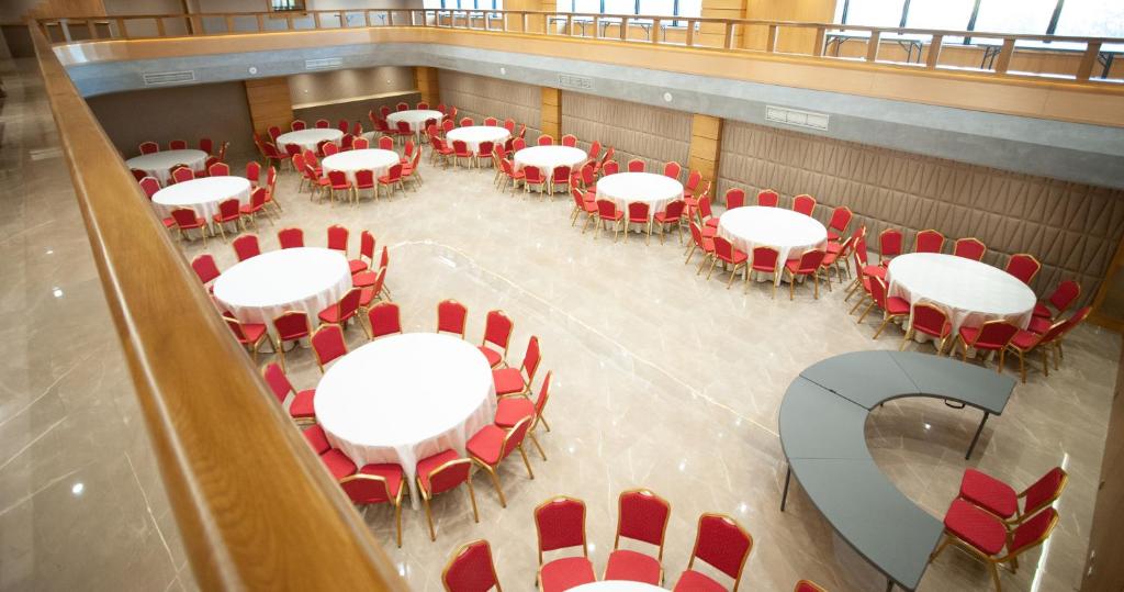 an overhead view of a room with white tables and red chairs at Doanesia Premium Hotel & Spa in Tirana