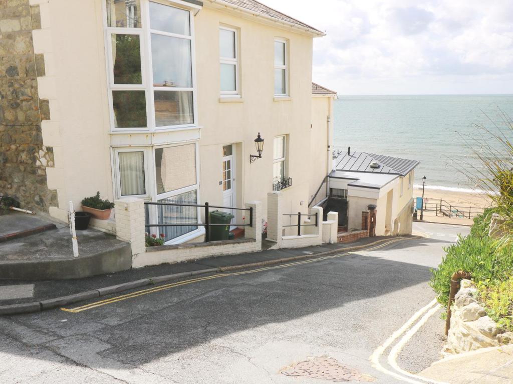 a house on the beach with the ocean in the background at Seaside in Ventnor