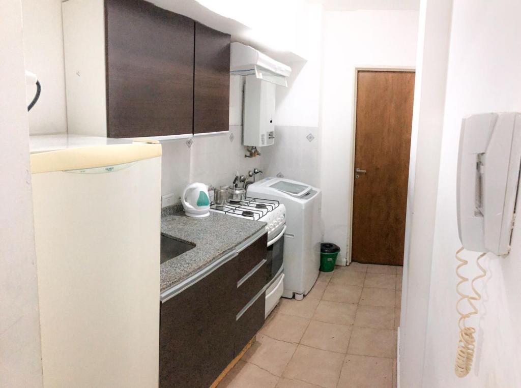 uma pequena cozinha com um fogão e um lavatório em Monoambiente - Barrio Martin em Rosário