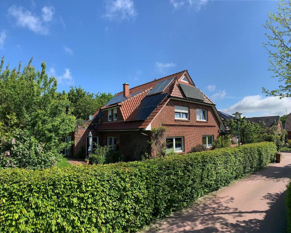 a brick house with a hedge in front of a road at Fewo Kurth - Haus Dulshorn in Wildeshausen