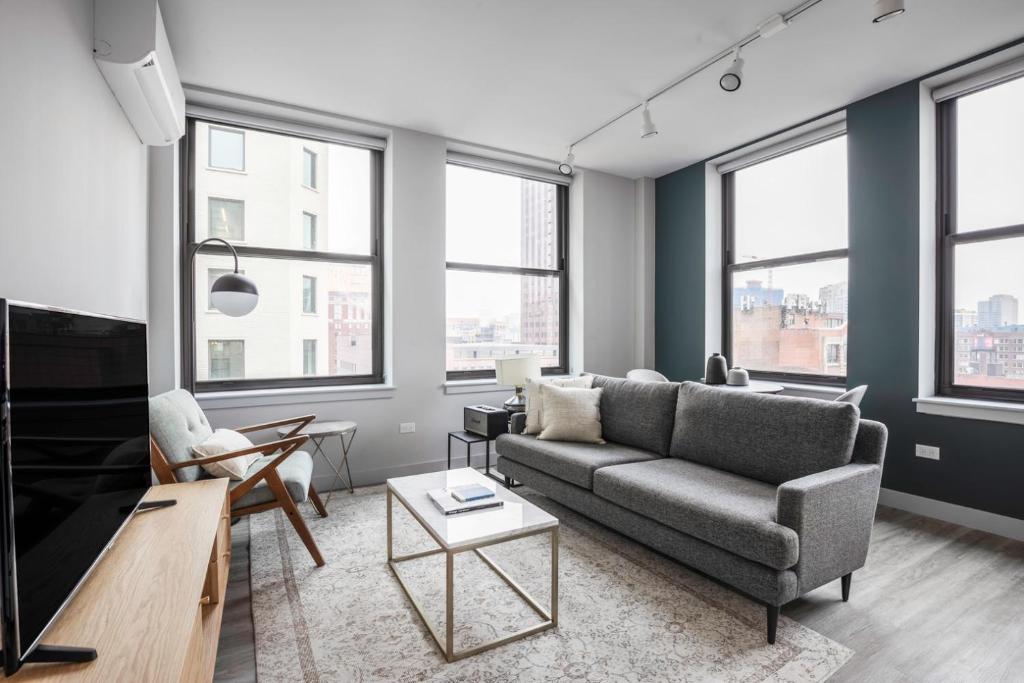 a living room with a couch and a tv at Loop 1BR wGym Roofdeck WD nr W Loop the L CHI-200 in Chicago
