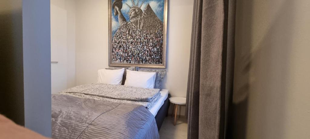 a small room with a bed and a picture on the wall at MM City Apartment Next to Arena in Tampere