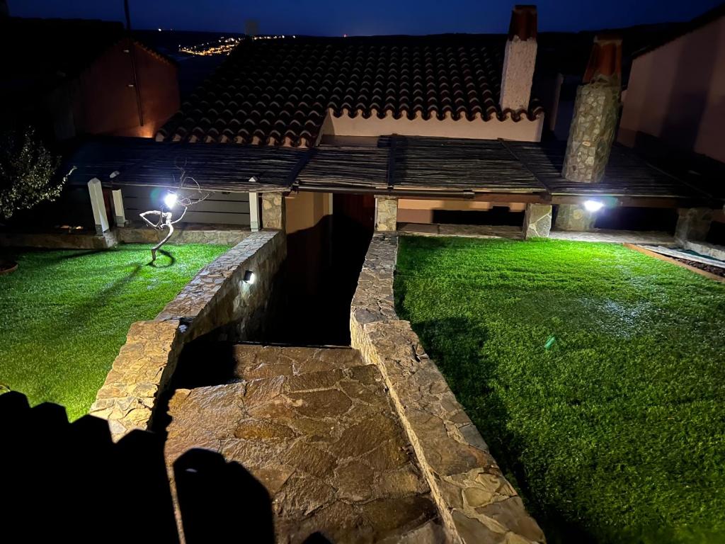 un patio trasero por la noche con césped verde en La Villa dell Artista con vista mare e dune - IUN Q7440 en Torre Dei Corsari