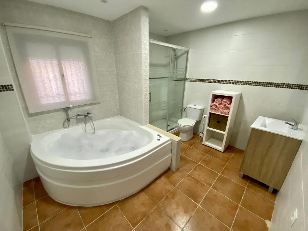 e bagno con vasca, servizi igienici e lavandino. di Casa Rural Villa Briar a Olvera