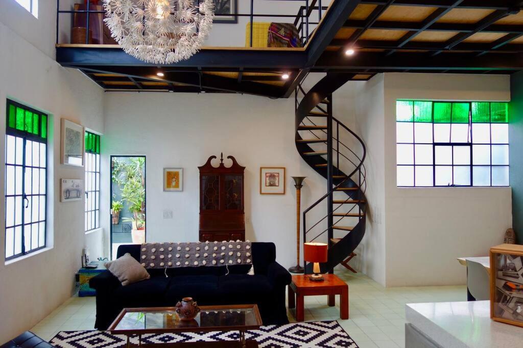 ein Wohnzimmer mit einem Sofa und einer Wendeltreppe in der Unterkunft The orchid terrace in Mexiko-Stadt