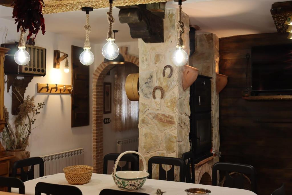 un comedor con una mesa y algunas luces en Casa Rural Anita en Torre Baja
