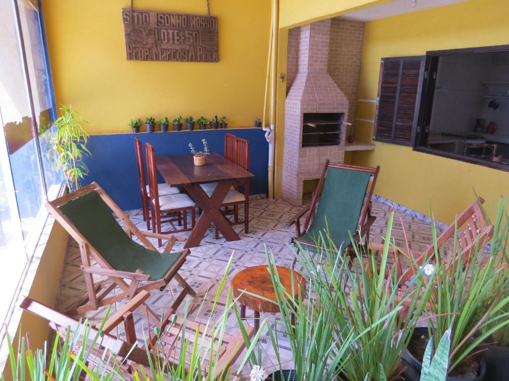 a patio with a table and chairs and a fireplace at Casa na Rua da Praia com TV e Wi-fi in Pontal do Paraná