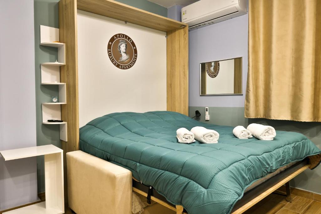 a bedroom with a green bed with four pillows at Apollo 3 - Luxury Apartment (City Center Studio) in Katerini