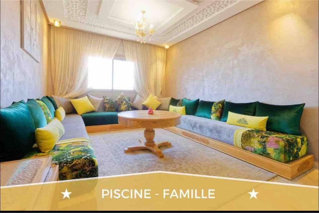 - un salon avec un canapé et une table dans l'établissement Chez ASSYL: résidence avec 3 piscines, à Marrakech