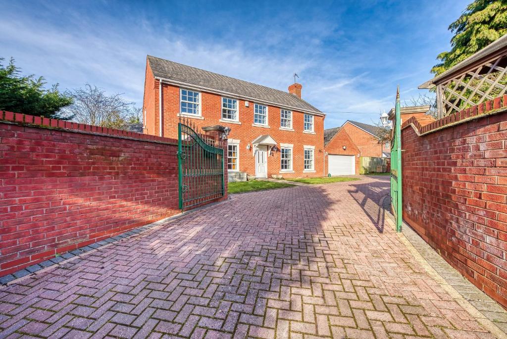 a brick wall with a gate in front of a house at Safari Stays - Gated - Sleeps 14 - Hot tub - Garden in Kidderminster