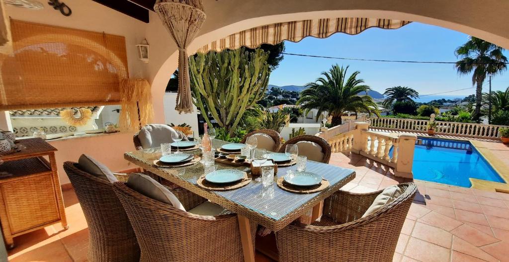 a dining room with a table and chairs and a pool at Casa Wens Bénimeit in Moraira