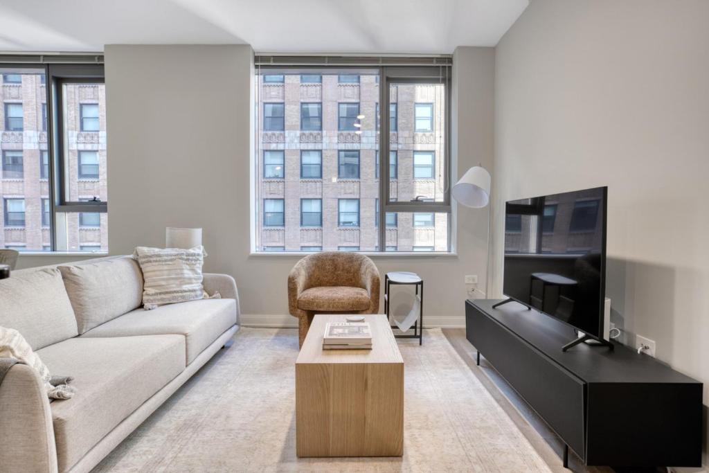 a living room with a couch and a tv at Loop 1BR w gym pool lounge 1 block from L CHI-700 in Chicago