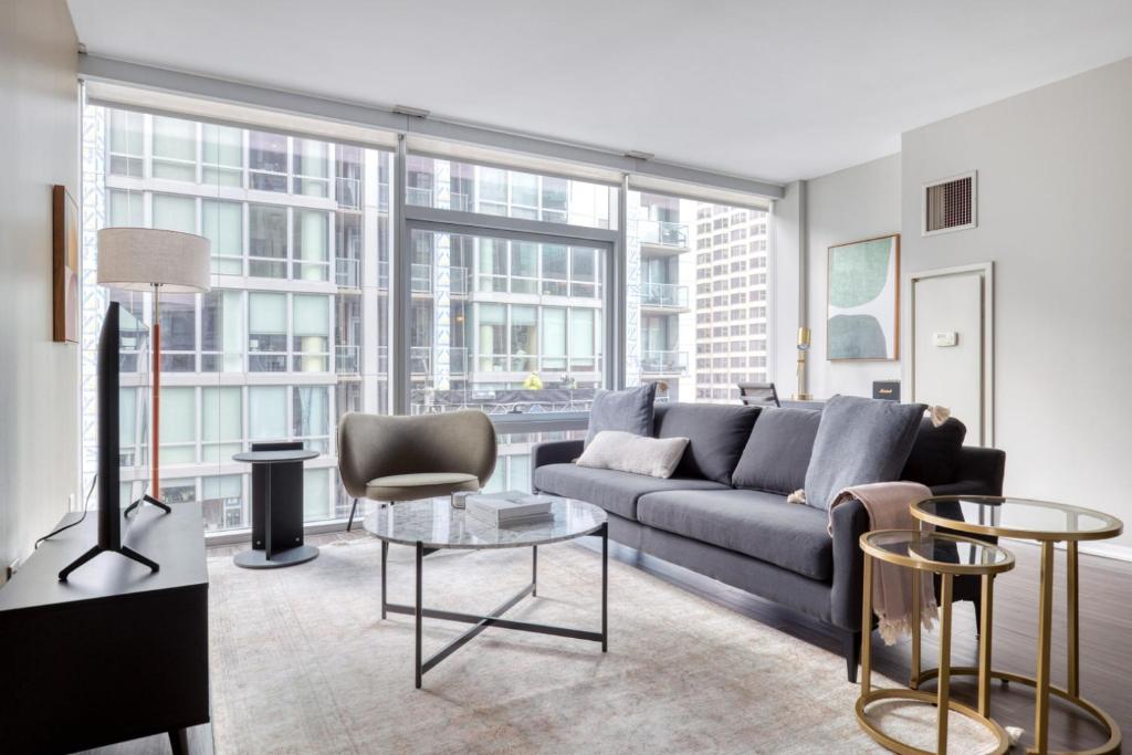 a living room with a couch and chairs and large windows at Streeterville 2br w pool gym nr Riverwalk CHI-880 in Chicago