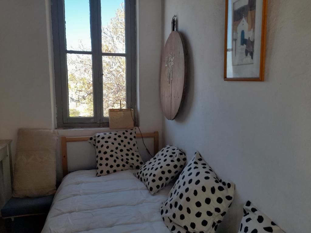 a bedroom with a bed with black and white pillows at Maison charmante in Hydra