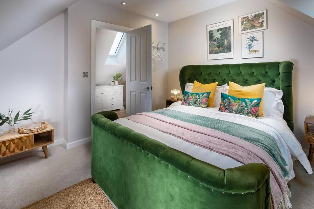 - un grand lit vert dans une chambre aux murs blancs dans l'établissement Roseland Apartment 5, à Arundel