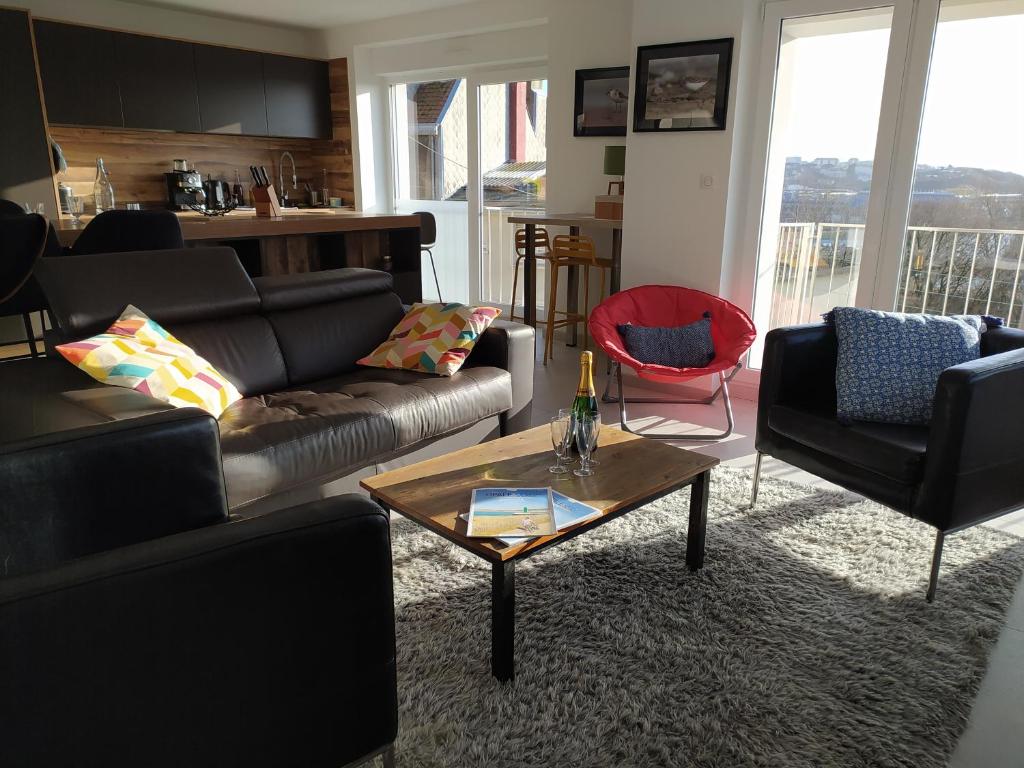 a living room with a couch and a coffee table at Face Nausicaa et plage vue panoramique in Boulogne-sur-Mer