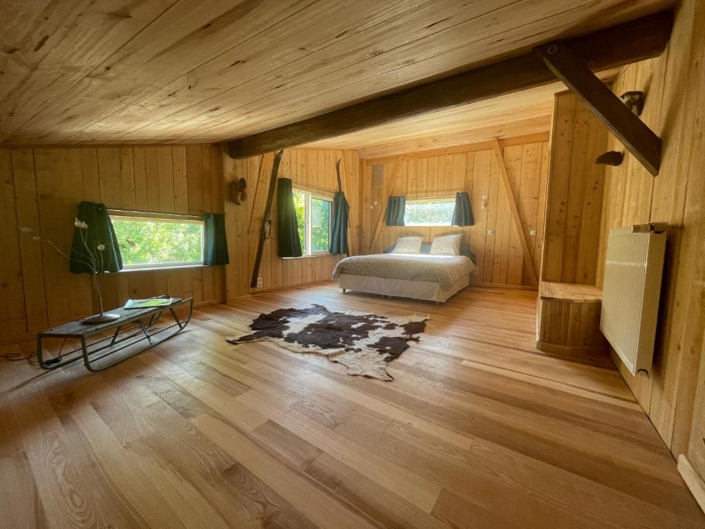 ein Schlafzimmer mit einem Bett in einer Holzhütte in der Unterkunft grande demeure d'exception in Clairvaux-les-Lacs