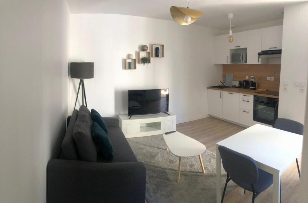 un salon avec un canapé, une télévision et une table dans l'établissement S&P home, à Tours