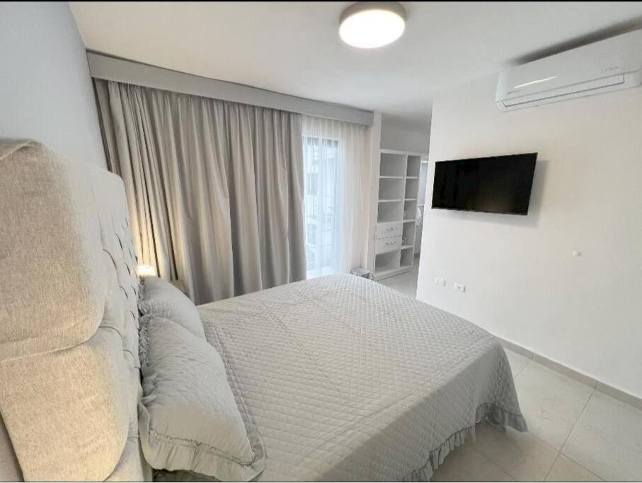 a white bedroom with a bed and a television at Departamento Exclusivo, High Apartment with Great Location 4-B in Matamoros
