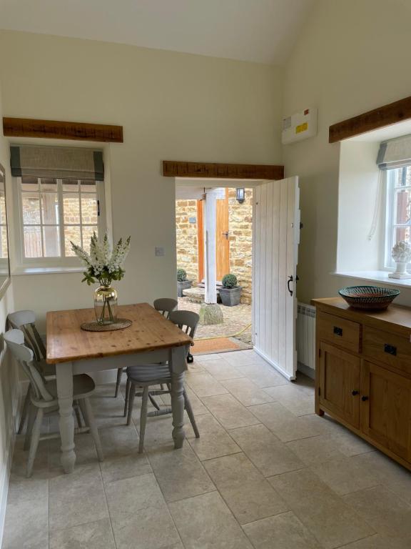 una cucina e una sala da pranzo con tavolo e sedie di The Cobbles a Towcester