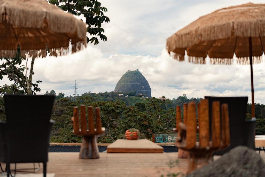 a view of a building in the distance with umbrellas at BubbleSky Glamping Guatapé in Guatapé