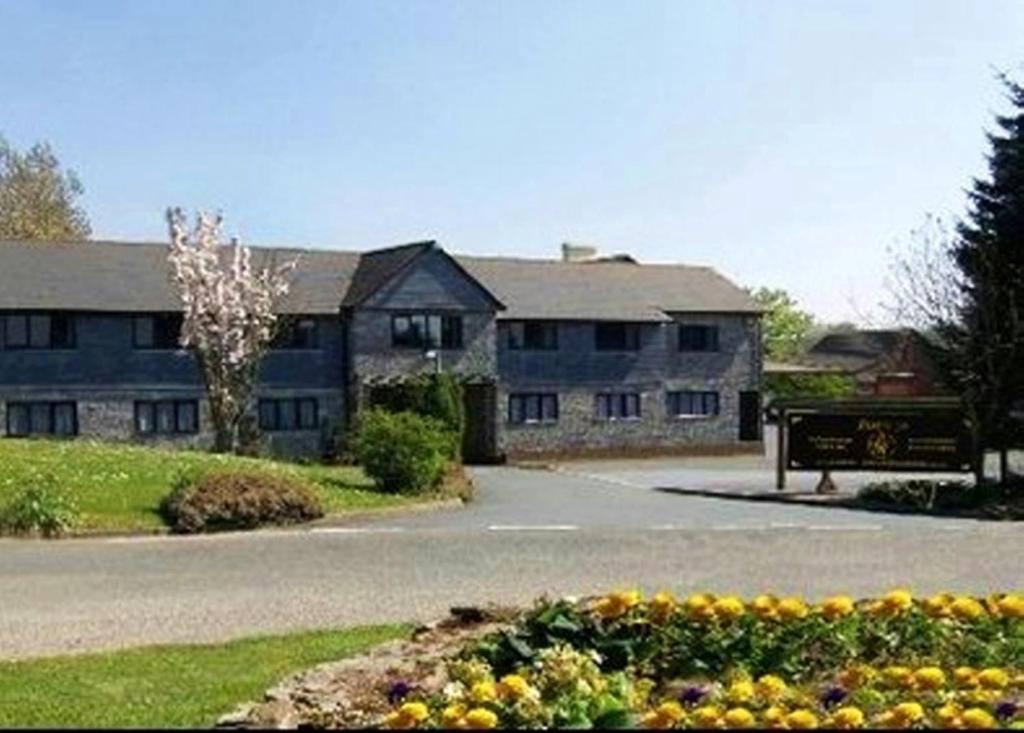 Un bâtiment avec un bouquet de fleurs devant lui dans l'établissement Smithaleigh Farm Rooms and Apartments, à Plymouth