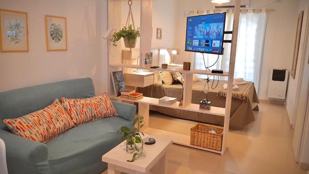 sala de estar con sofá azul y TV en Monoambiente céntrico La Plata en La Plata