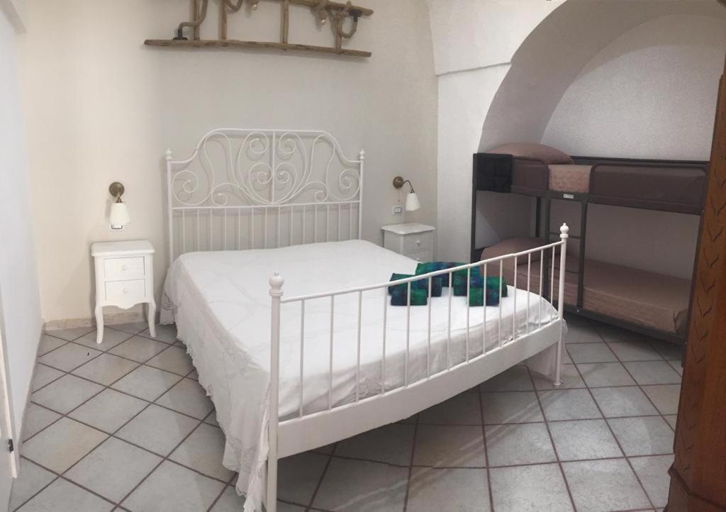 una camera con un letto bianco e due comodini di Casa Nimeca a Palagiano