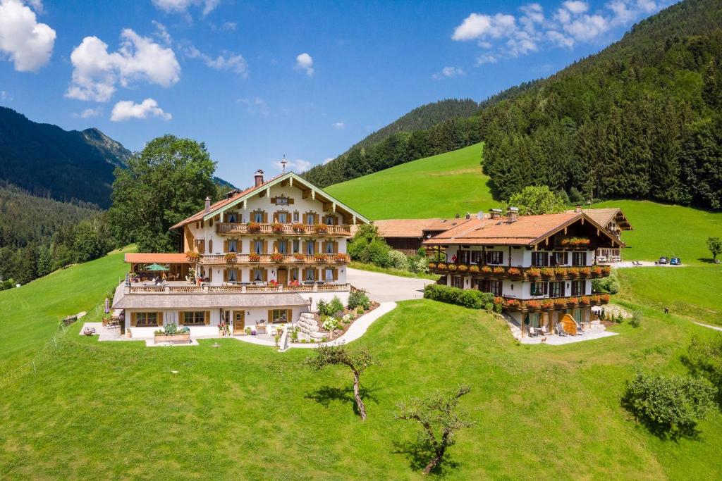 a large building on top of a green hill at Steinberger Hof in Ruhpolding