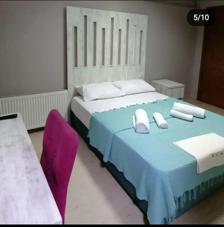 a bedroom with a blue bed and a purple chair at Tekirlife otel in Tekirdağ