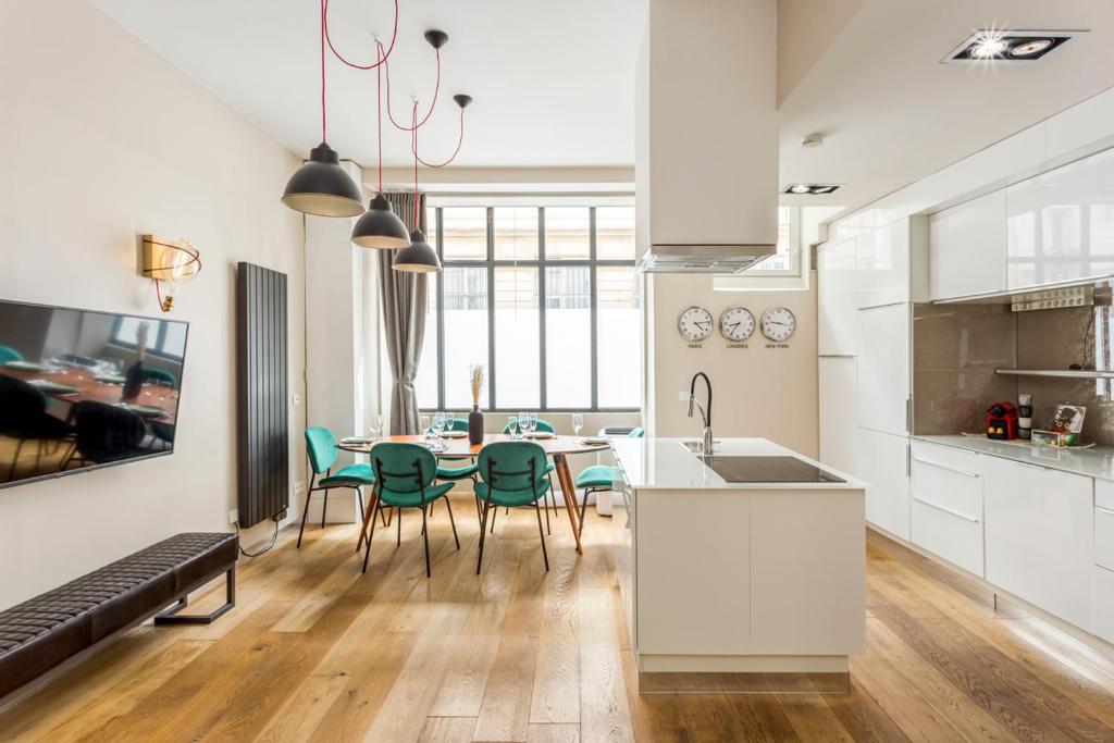 una cucina e una sala da pranzo con tavolo e sedie di Design et confort near Champs Elysees a Parigi