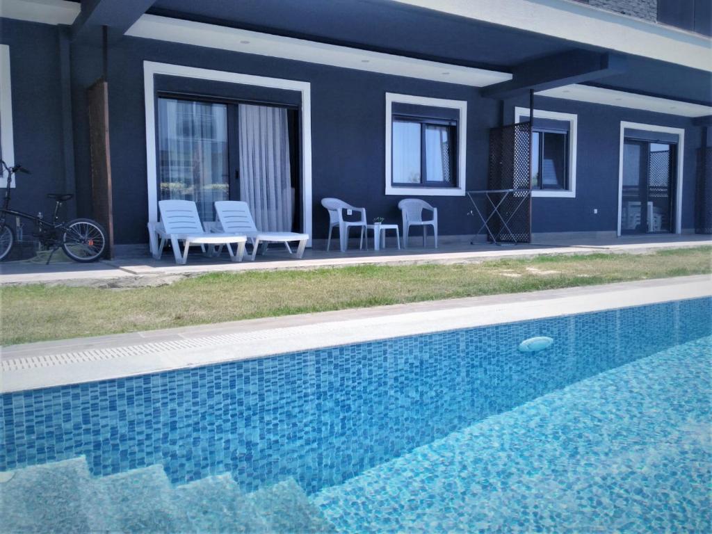 a swimming pool in front of a house at Mali Garden Residence in Side