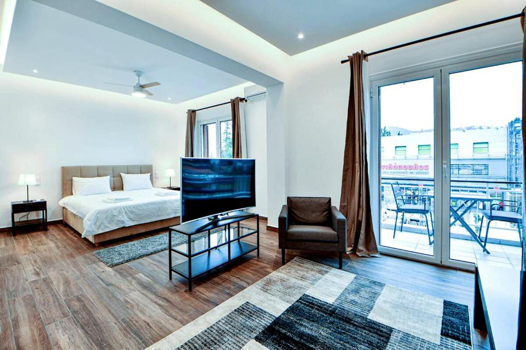 a bedroom with a bed and a television and a balcony at Boutique40 Luxury Apartment in Athens