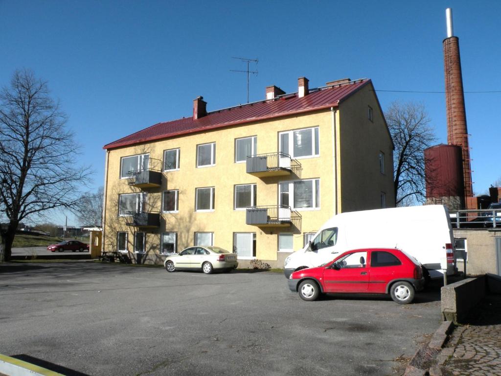 ein roter Van auf einem Parkplatz vor einem Gebäude geparkt in der Unterkunft Guesthouse Kupittaa in Turku