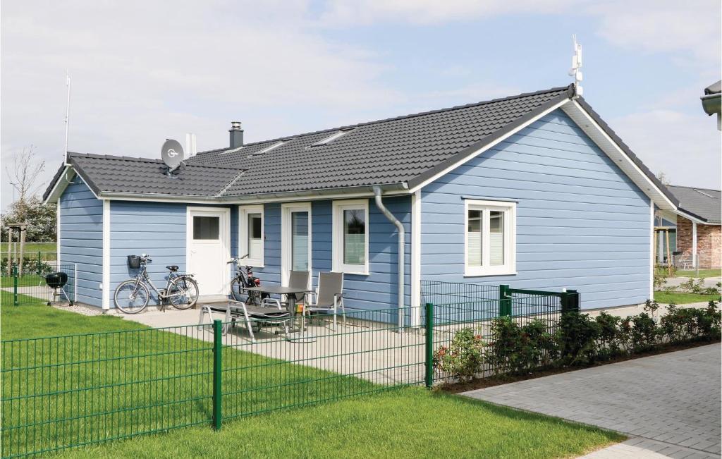 ein blaues Haus mit einem Zaun davor in der Unterkunft Beautiful Home In Dagebll With Wifi in Dagebüll