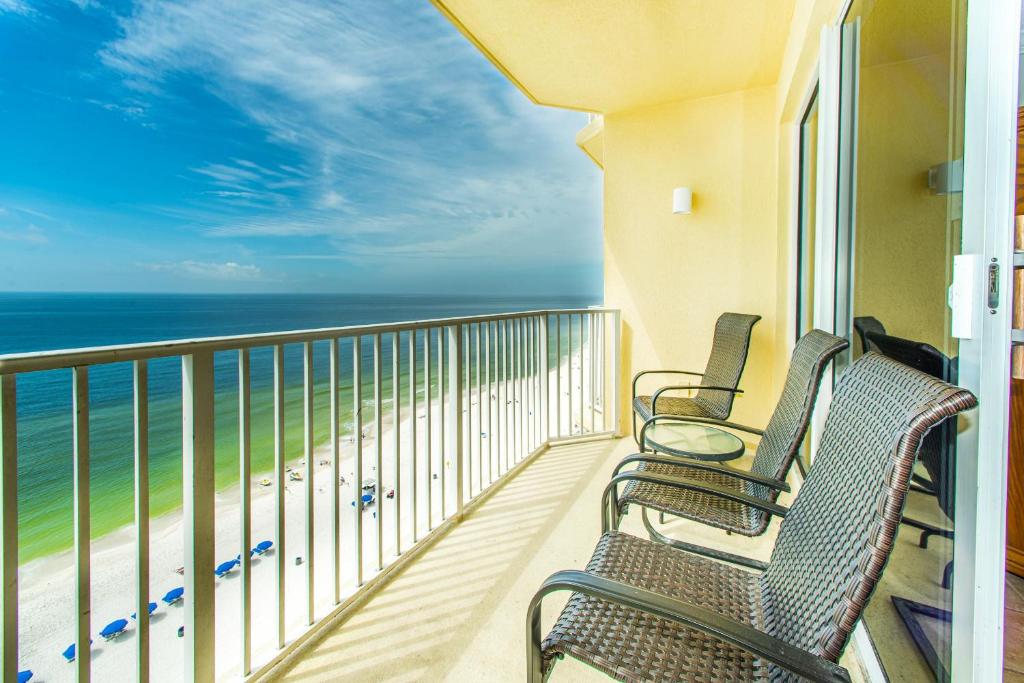 een balkon met vier stoelen en de oceaan bij Boardwalk 1406 in Panama City Beach
