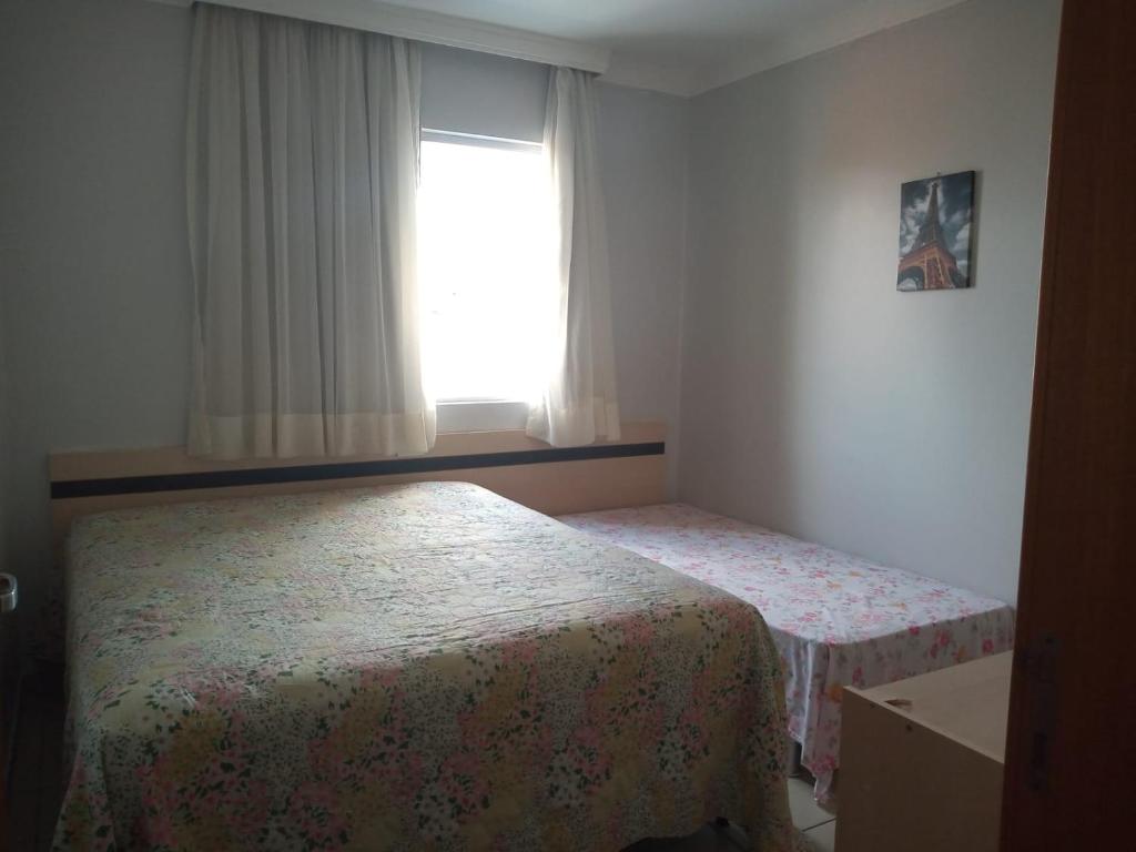 sypialnia z 2 łóżkami i oknem w obiekcie APARTAMENTO AGUAS DA SERRA 713 A w mieście Rio Quente