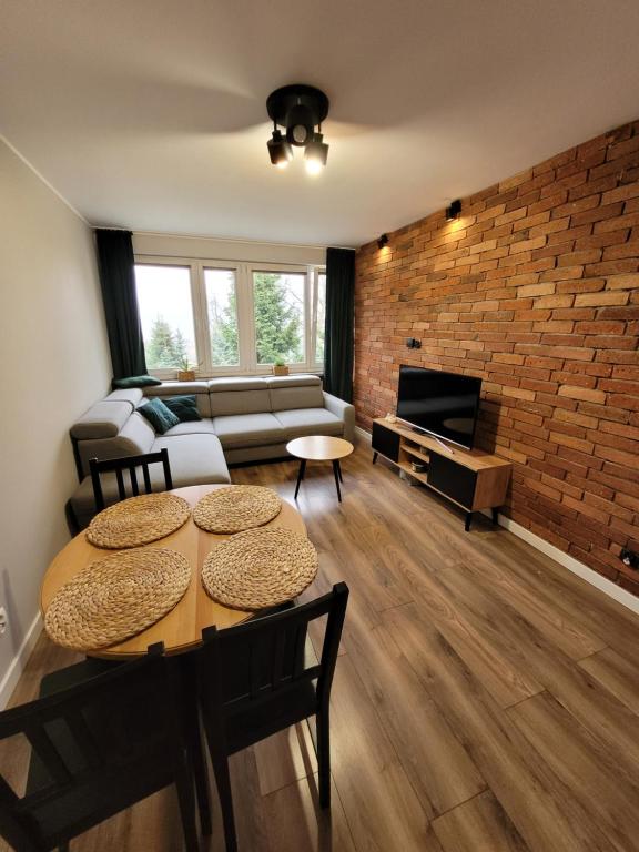 een woonkamer met een bank en een tafel bij Apartament Stadion in Kamienna Góra