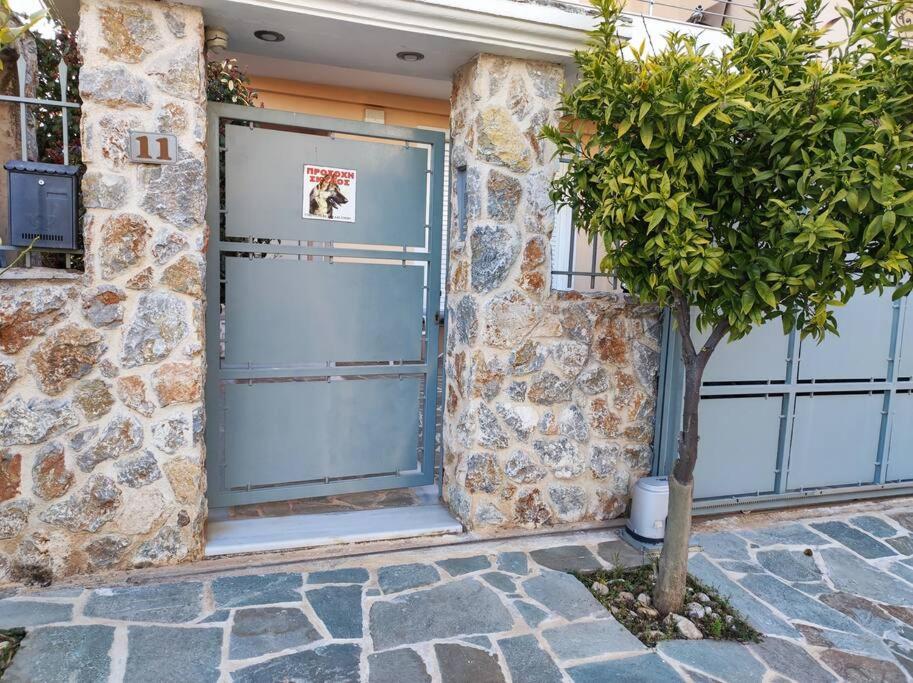 una puerta de garaje azul con un árbol delante de un edificio en Pegasus cosy house, en Atenas