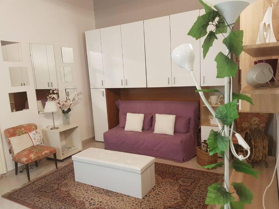 sala de estar con sofá púrpura y silla en a casa di Max, en Trezzo sullʼAdda