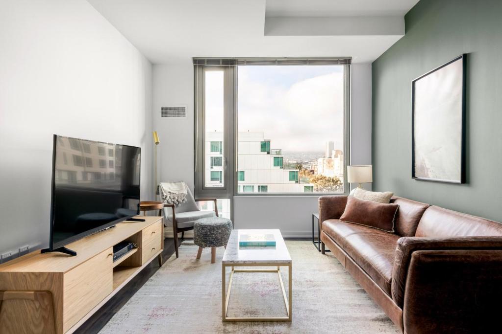 a living room with a couch and a television at SoMa 2BR w Gym Roofdeck nr Muni BART Airbnb SFO-297 in San Francisco