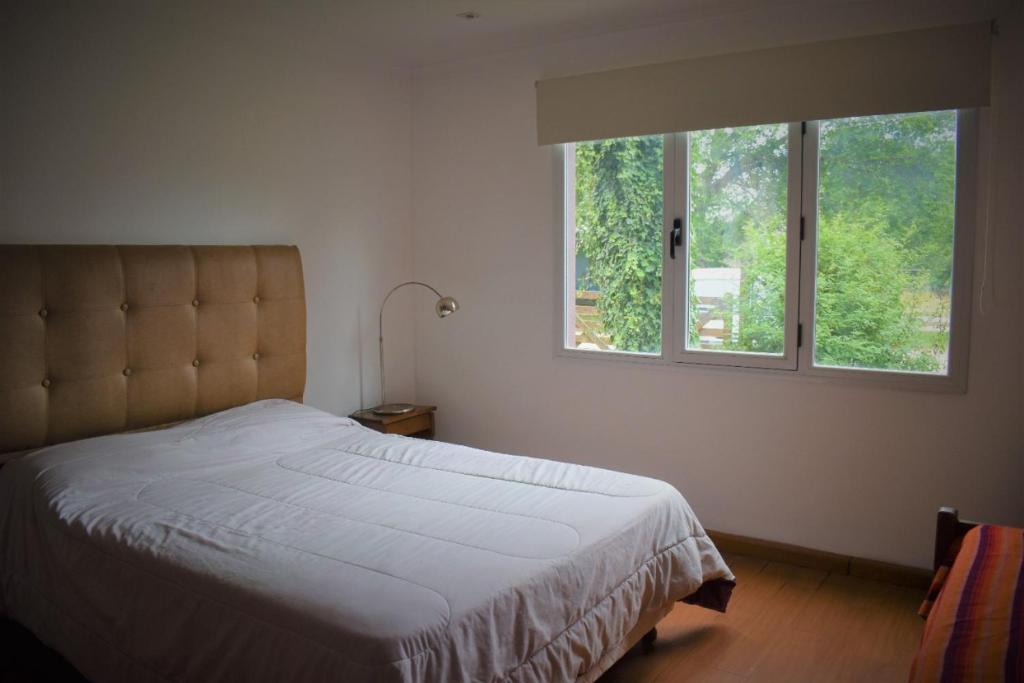 1 dormitorio con cama y ventana en Casa Los Acantilados en Mar del Plata