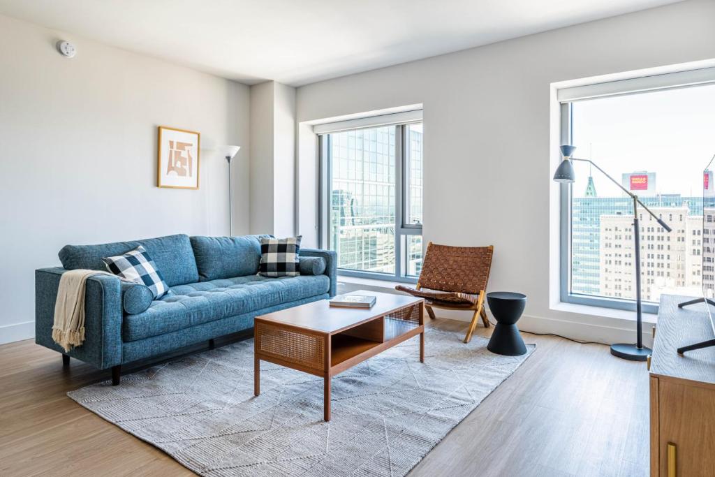 a living room with a blue couch and a table at Oakland 2BR w AC WD Sky Deck next to BART SFO-528 in Oakland