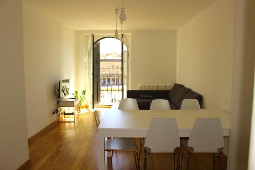 sala de estar con mesa blanca y sillas en Aloha Apartamentos en Pamplona