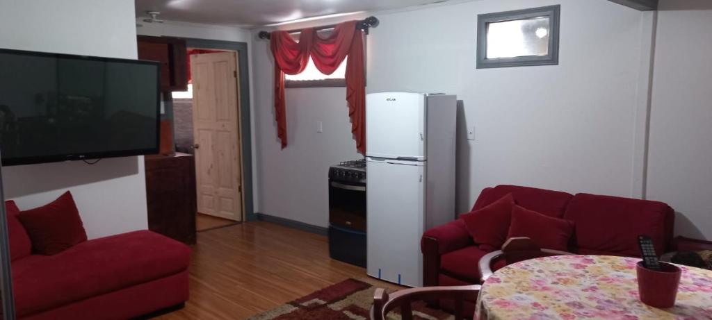 een woonkamer met een rode bank en een tv bij Casa Dota in Santa María