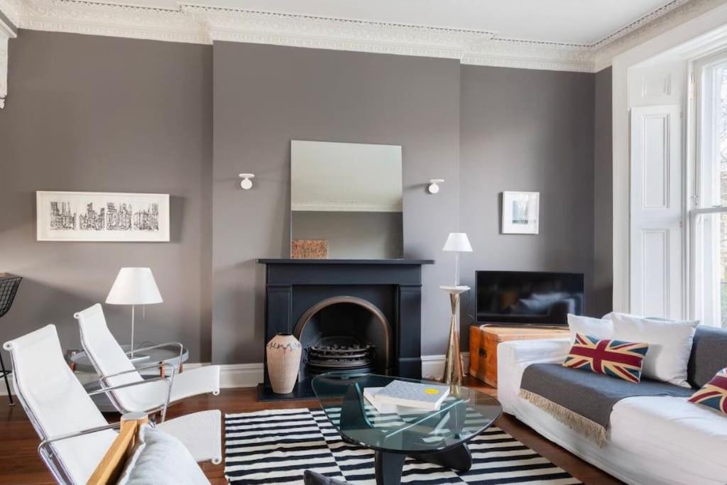a living room with a couch and a fireplace at Stunning Notting Hill APT, Beautiful Street in London