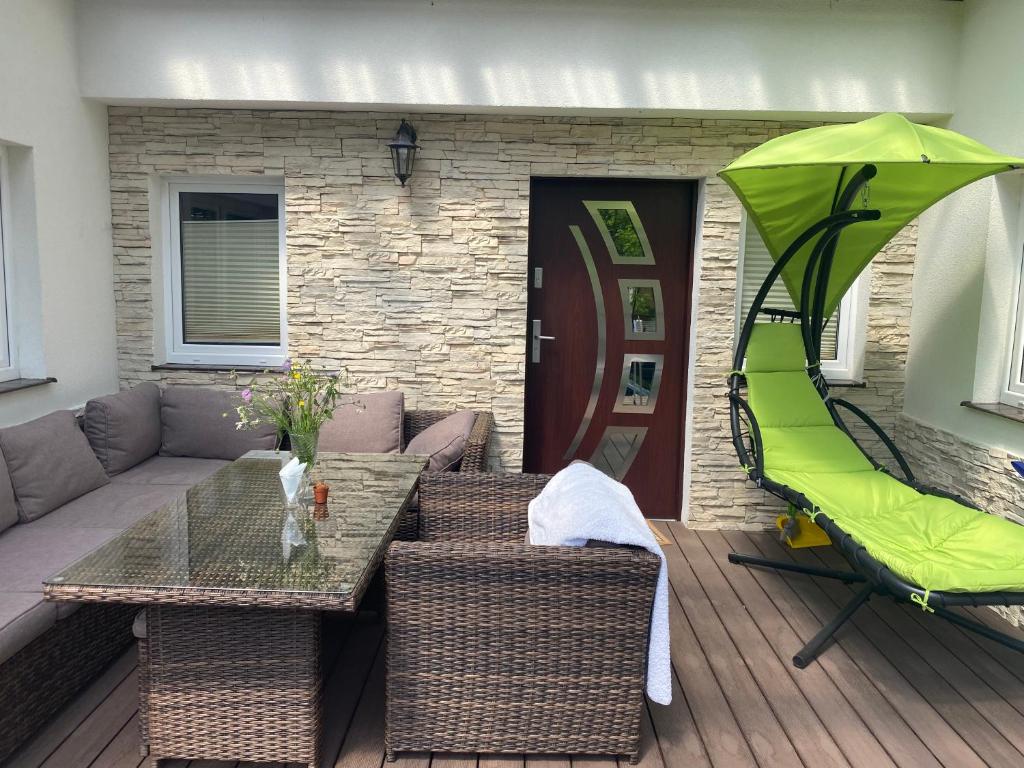 un patio con una mesa y una sombrilla verde en Drift Away en Mielno